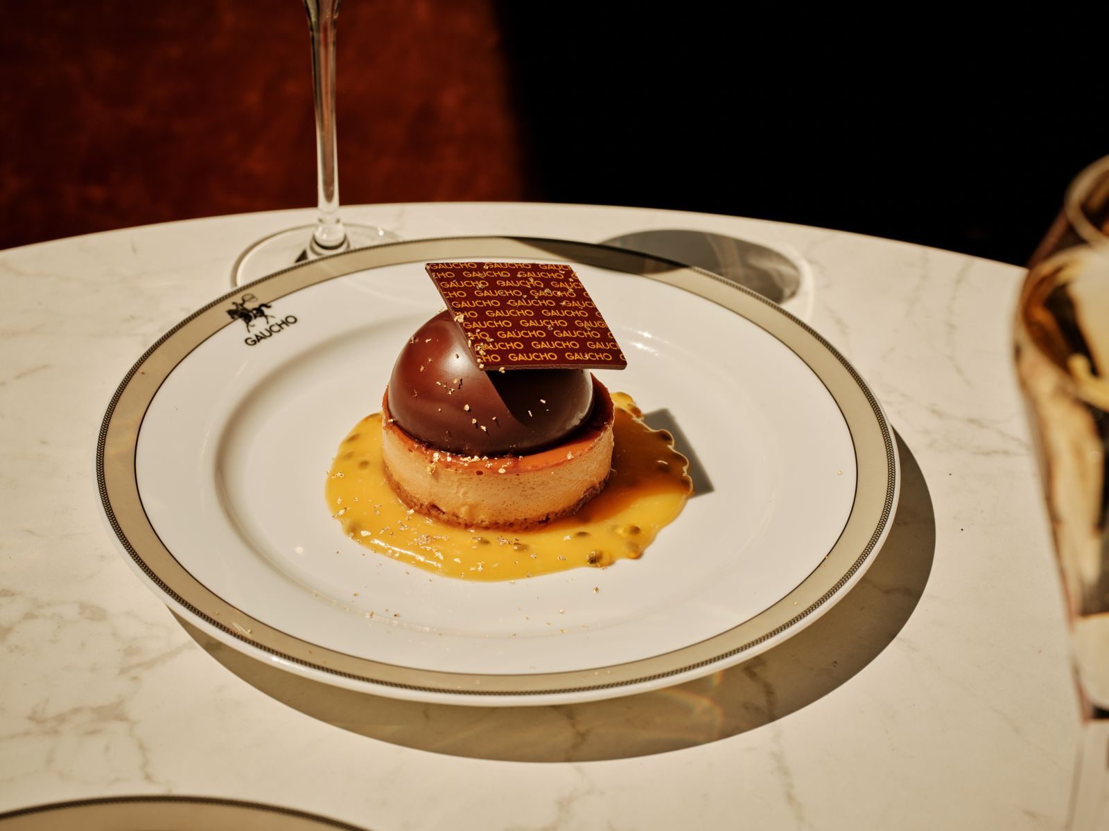 Class of 2026 cheesecake with dulce de leche filling, gilded chocolate dome and passion fruit